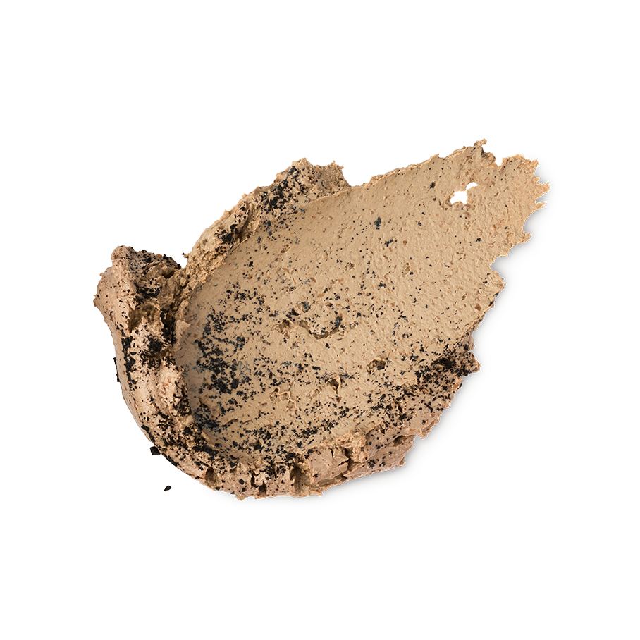 A textured swipe of Black Tea Mochi face mask on a light gray background. The thick, creamy beige formula is heavily speckled with crushed black tea particles throughout.